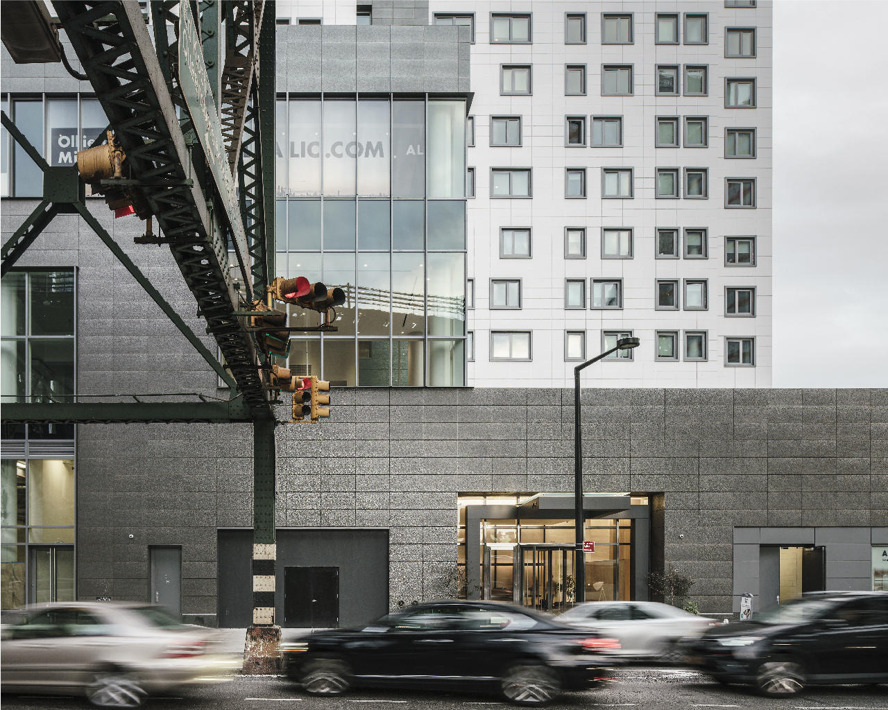 Alta LIC Tower Street view of podium with custom TEXTURED porcelain and and Technic collection at tower beyond